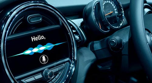 A car infotainment screen displaying "Hello," with a voice wave and microphone icon, indicating an active voice command feature.