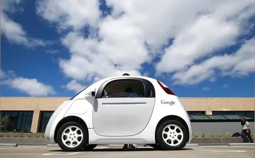 A white, compact autonomous vehicle developed by Google, with no visible driver controls.