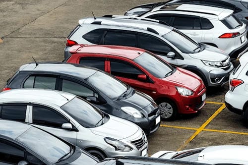 An overhead shot of a busy parking lot filled with various cars.